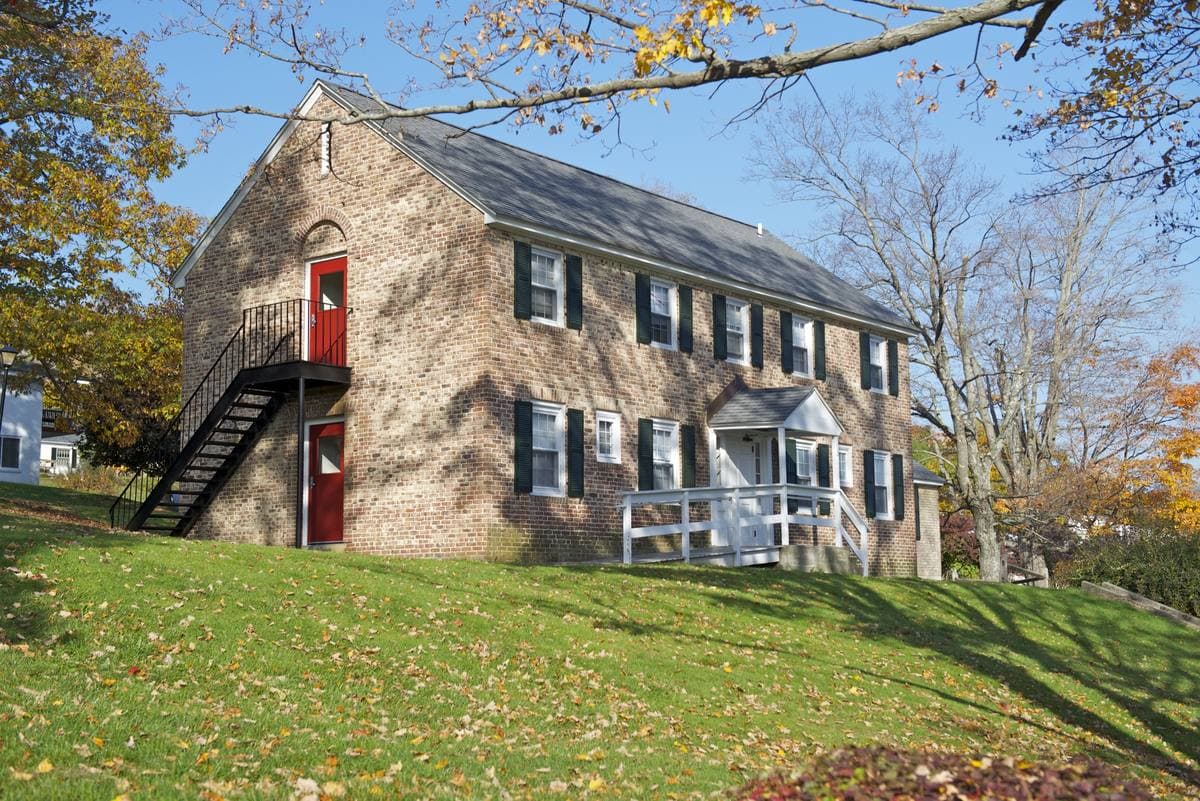 A Victorian home with detailed painted trim on a residential street in Brookline, Massachusetts