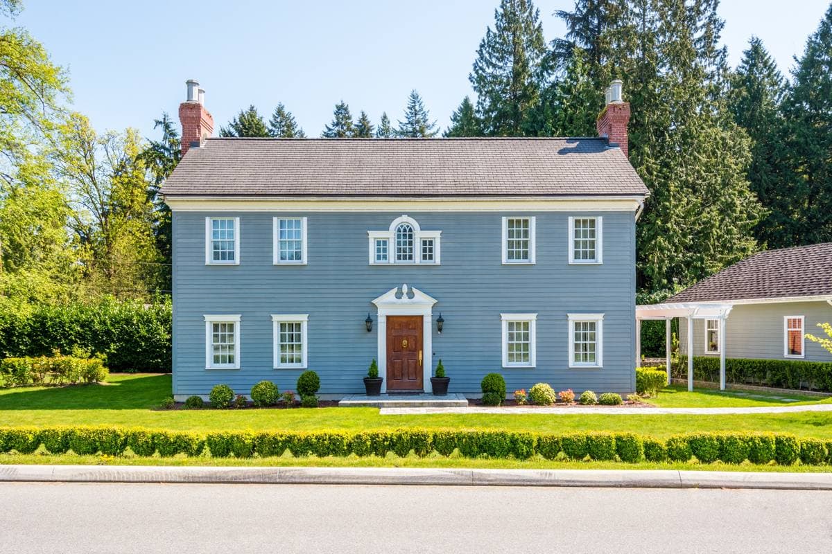 A large Victorian home with painted trim and mature trees in Newton, Massachusetts